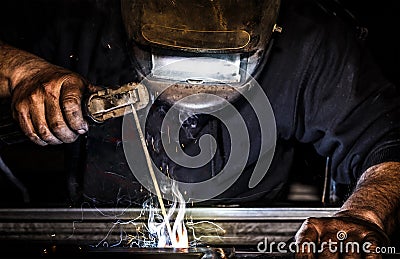 Professional mask protected welder man working on metal welding and sparks metal Stock Photo