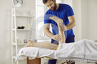 Professional masseur, physiotherapist, chiropractor or osteopath massaging woman& x27;s legs Stock Photo