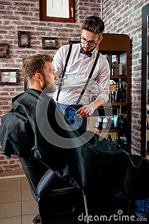 Professional master hairdresser cuts client beard Stock Photo