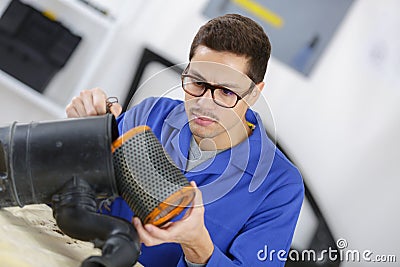 Professional mechanic cleaning filter in workshop Stock Photo