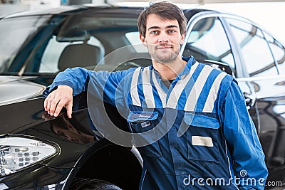 Professional mechanic leaning against a car Stock Photo