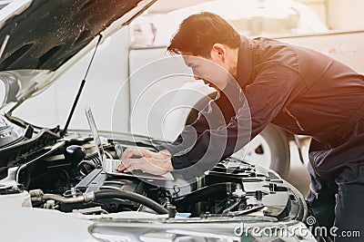 professional mechanic male work tune engine ignition timing in ecu with laptop computer in auto service garage racing shop Stock Photo
