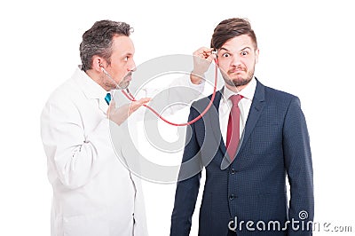 Professional medic cheking head of insane lawyer Stock Photo