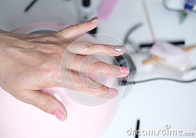 Professional nail care, manicure in a beauty salon. Nail design with colored gel polish. Stock Photo