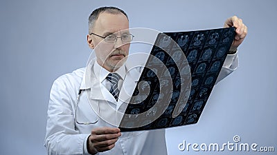 Professional neurosurgeon checking MRI brain image, headache treatment, trauma Stock Photo