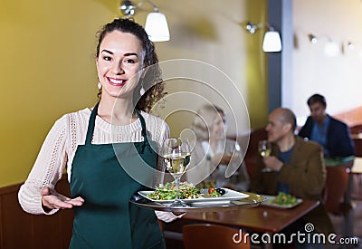 Professional nippy with tray posing at table Stock Photo