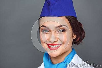 Professional Occupation. Stewardess standing on grey smiling cheerful close-up Stock Photo