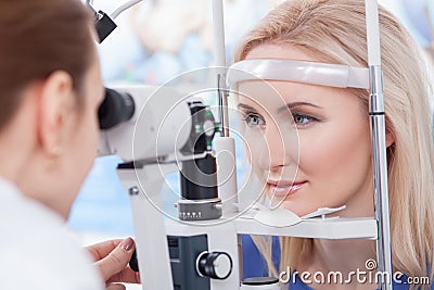 Professional oculist is checking human vision with equipment Stock Photo