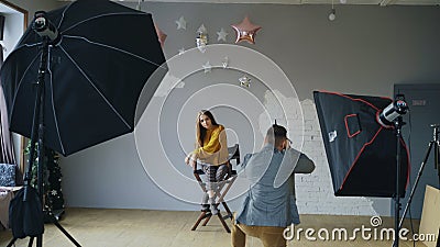 Professional photographer man taking photo of beautiful model girl with digital camera in studio Stock Photo