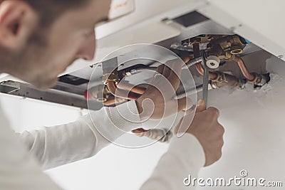 Professional plumber checking a boiler Stock Photo