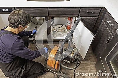 Professional Plumber Drain Cleaning Stock Photo