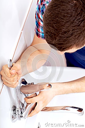 Professional plumber repairing a tap Stock Photo