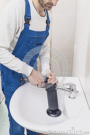 Professional plumber unclogging a sink Stock Photo