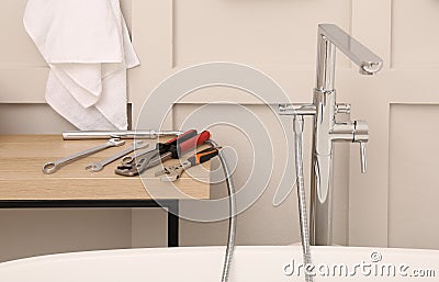 Professional plumbing tools and installed water tap in bathroom Stock Photo