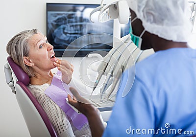 Professional positive doctor man talking with patient in medical chair Stock Photo