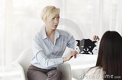 Professional Psychologist Testing Female Patient Showing Inkblot Picture In Office Stock Photo