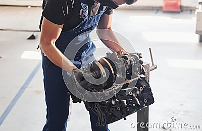 Professional repairman works with broken automobile engine Stock Photo