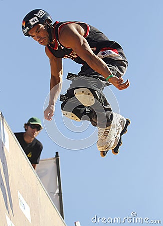 A professional roller skater performs a trick during an extreme sports outdoors show vertical Editorial Stock Photo