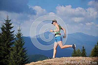 Professional runner training run downhill in the mountains. Stock Photo