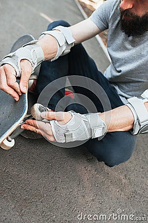 Professional skater checks his skateboard Stock Photo