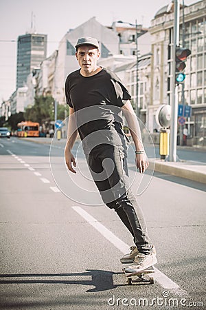 Professional skater riding skate on streets through cars and traffic Stock Photo