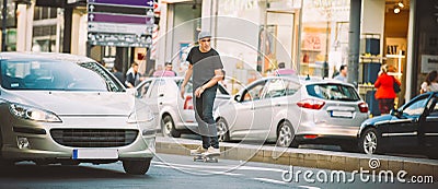 Professional skater riding skate on streets through cars and traffic Stock Photo