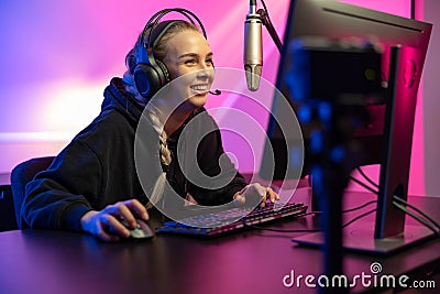 Professional smiling esport gamer girl live streaming and plays online video game on PC Stock Photo