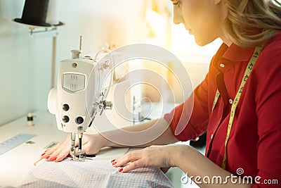 Professional tailor designer woman sewing new skirt on sewing machine. Stock Photo