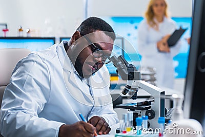 Professional team of scientists is working on a vaccine in a modern scientific research laboratory. Genetic engineer Stock Photo