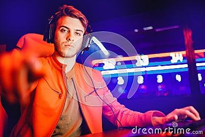 Professional video gamer playing online games tournaments pc computer with headphones, Blurred red and blue background Stock Photo