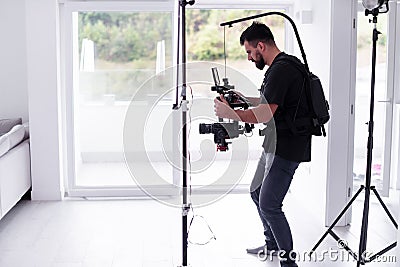 Professional videographer with gimball video slr recording video at home Stock Photo
