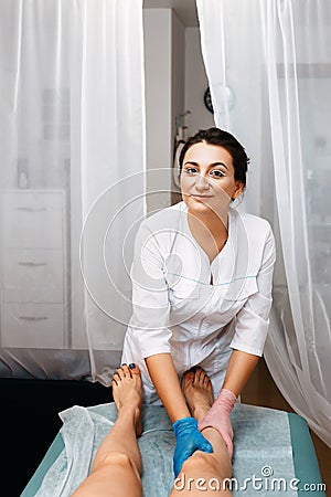 Professional wax master. She is wearing a white robe and smiling Stock Photo