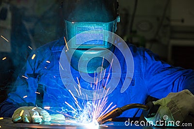 Professional welder welding metal pieces in steel construction Stock Photo