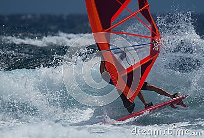 Professional windsurfer riding high waves Stock Photo