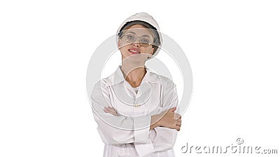 Professional woman in lab coat and white hardhat walking and smiling on white background. Stock Photo