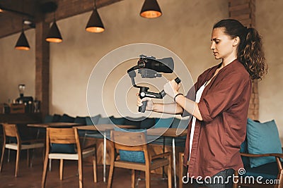Professional woman videographer with gimball video slr Stock Photo