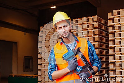Professional woodworker in hardhat holding pneumatic hammer Stock Photo