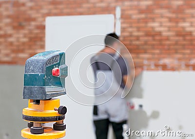 Professional worker lays bricks on the wall using laser level Stock Photo