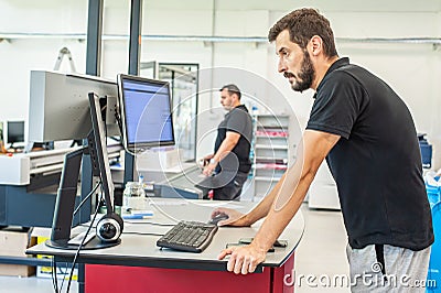 Professional worker printmaker technician operator works in modern printing plant Stock Photo