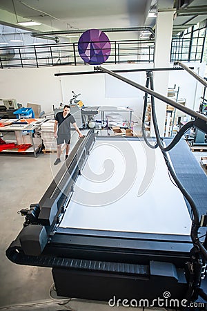 Professional worker printmaker technician operator works in modern printing plant Stock Photo