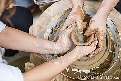 Male Potter Working with Female Apprentice. Working with Clay Lump on Potter`s Wheel Stock Photo