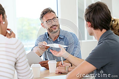 Professor distributing copies to students Stock Photo