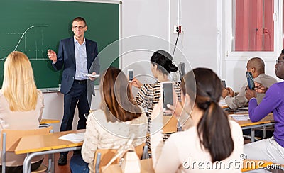 Professor explaining function graph to adult students in auditorium Stock Photo