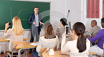 Professor explaining function graph to adult students in auditorium Stock Photo