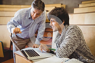 Professor helping a student in classroom Stock Photo