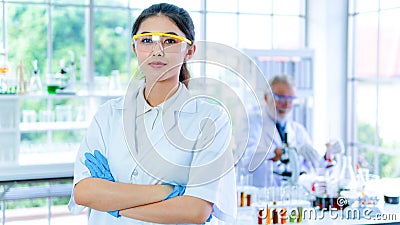 Professor woman researcher white gown stands confident with face concentration. With background interior white lab and the senior Stock Photo