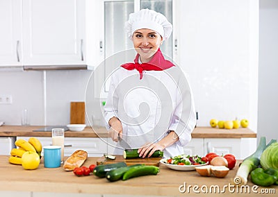 Proffesional woman cook in white uniform chopping vegetables Stock Photo