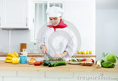 Proffesional woman cook in white uniform chopping vegetables Stock Photo