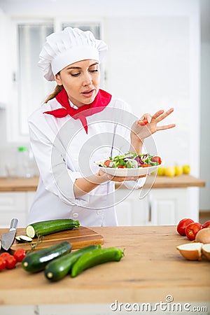 Proffesional woman cook in white uniform chopping vegetables Stock Photo
