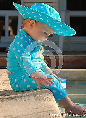 Profile of baby with feet in swimming pool Stock Photo